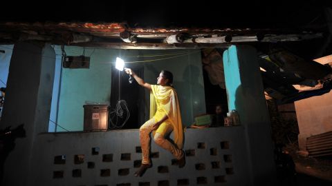 A girl switches on a light powered by solar energy in the village of Morabandar on Elephanta Island, off the coast of Mumbai.