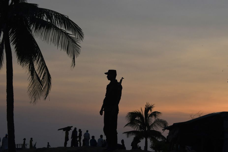 A Bangladeshi border guard keeps watch September 16 near the beach of Sharapuri Dwip, where many Rohingya refugees land after crossing from Myanmar.