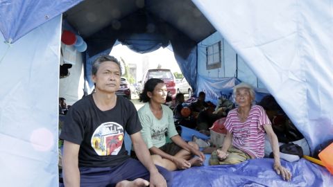 Wayan sits with his family at the Swecapura evacuation center in Bali.