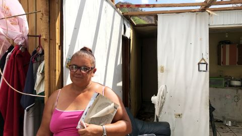 Julia Rivera, a school secretary, standing in her home which now has no roof. 