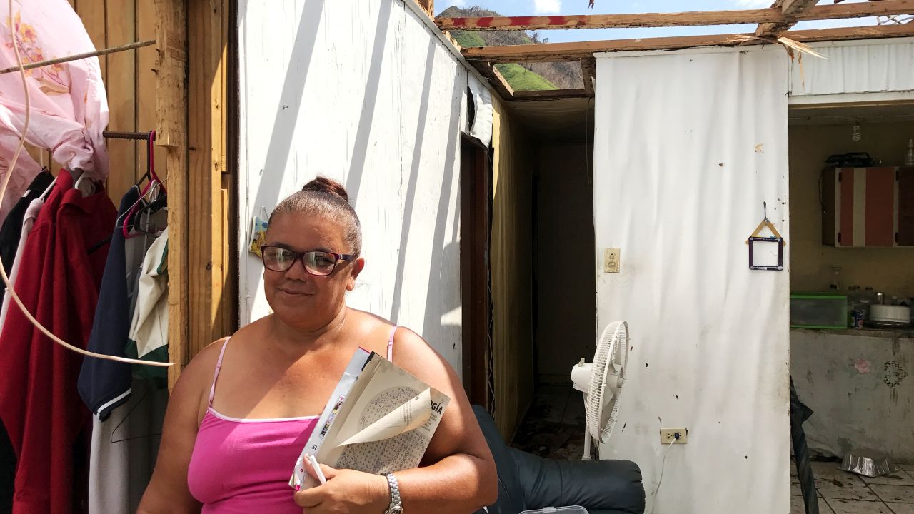 Julia Rivera, a school secretary, standing in her home which now has no roof.