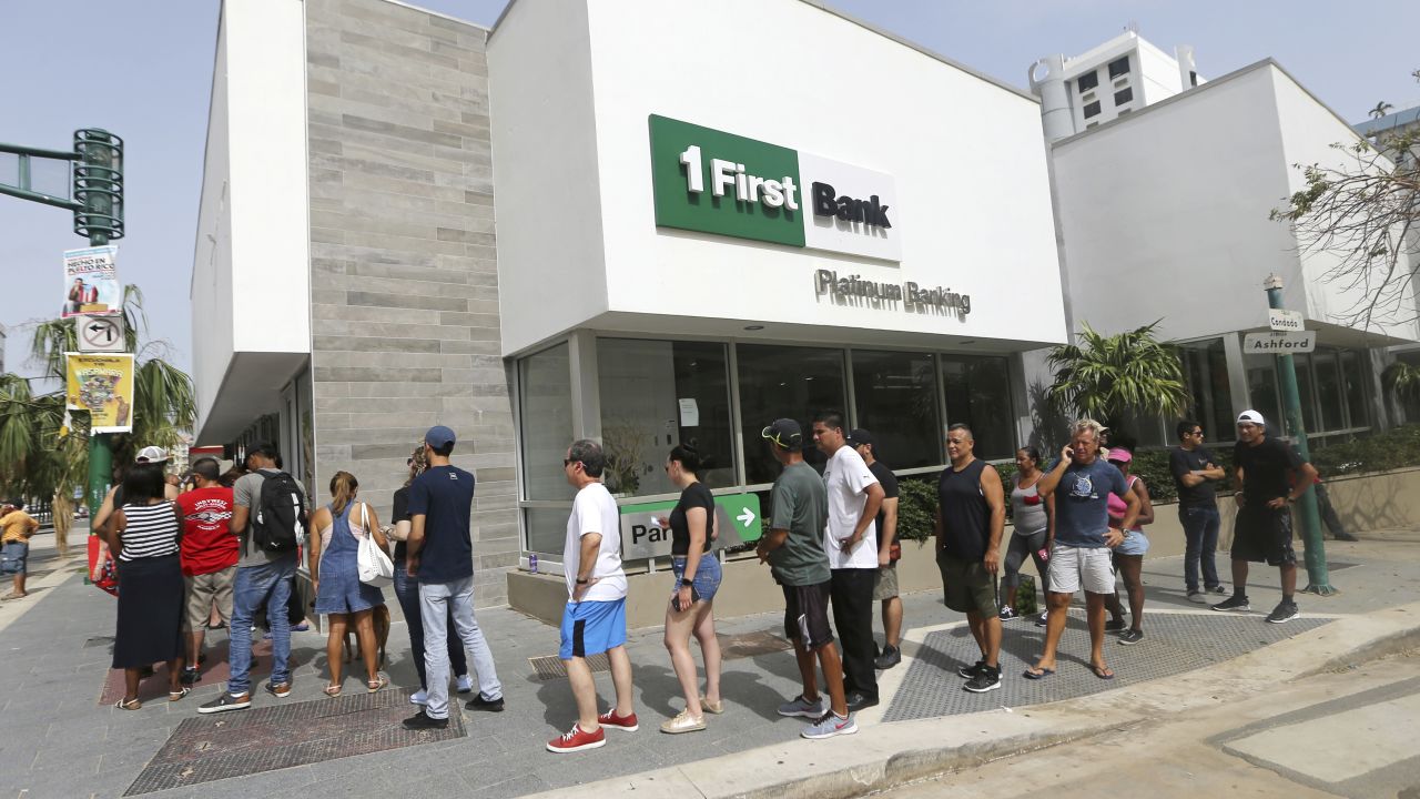 Long lines are a familiar sight in Puerto Rico. Here people wait to withdraw cash from a San Juan bank.