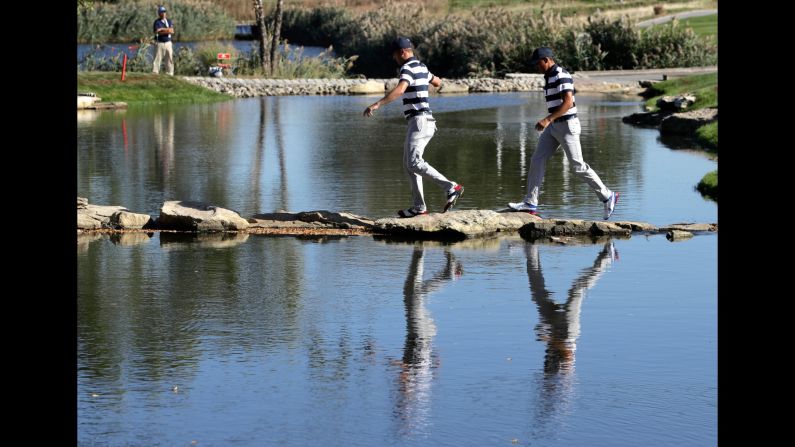 Avoiding the drink. Thomas, left, and Fowler, right, walk to the 13th hole during their foursomes match.