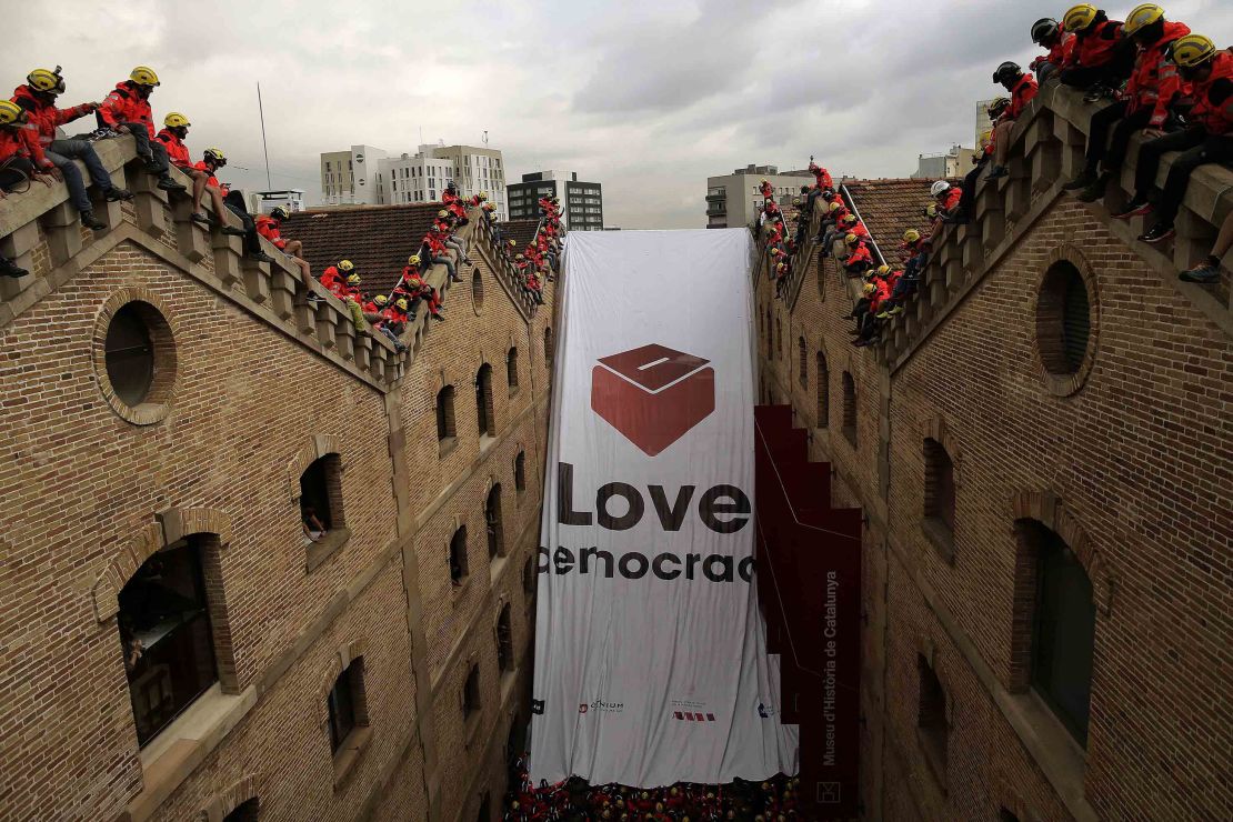 Catalan firefighters unfold a banner with a ballot box and the words "Love democracy" at the Museum of History of Catalonia in Barcelona on Thursday.