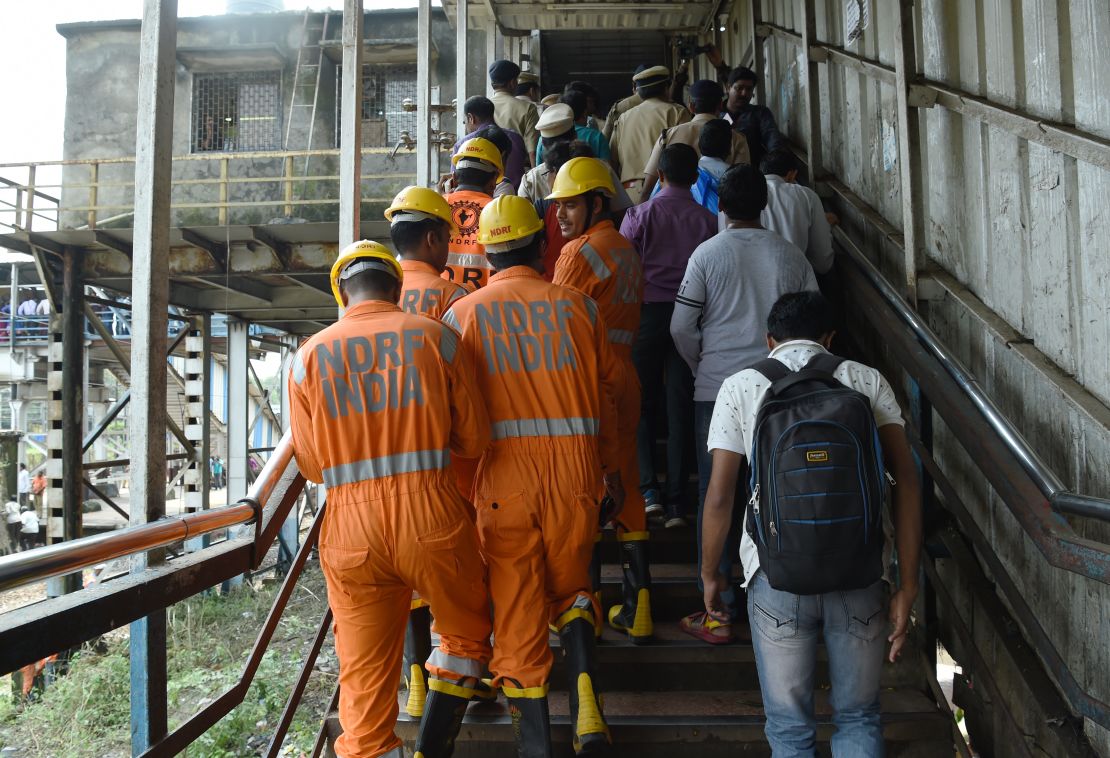 Indian rescue teams inspect the bridge where the deadly stampede in Prabhadevi train station took place.