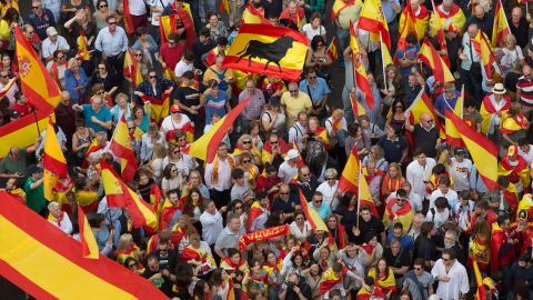 People wave Spanish  flags as thousands demonstrate Saturday in Madrid in favor of national unity.