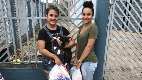 Eyleen Gonzalez with her stepsister, Amathys Santana, and her puppy, Lena, after receiving food from Daddy Yankee in Toa Baja, Puerto Rico.