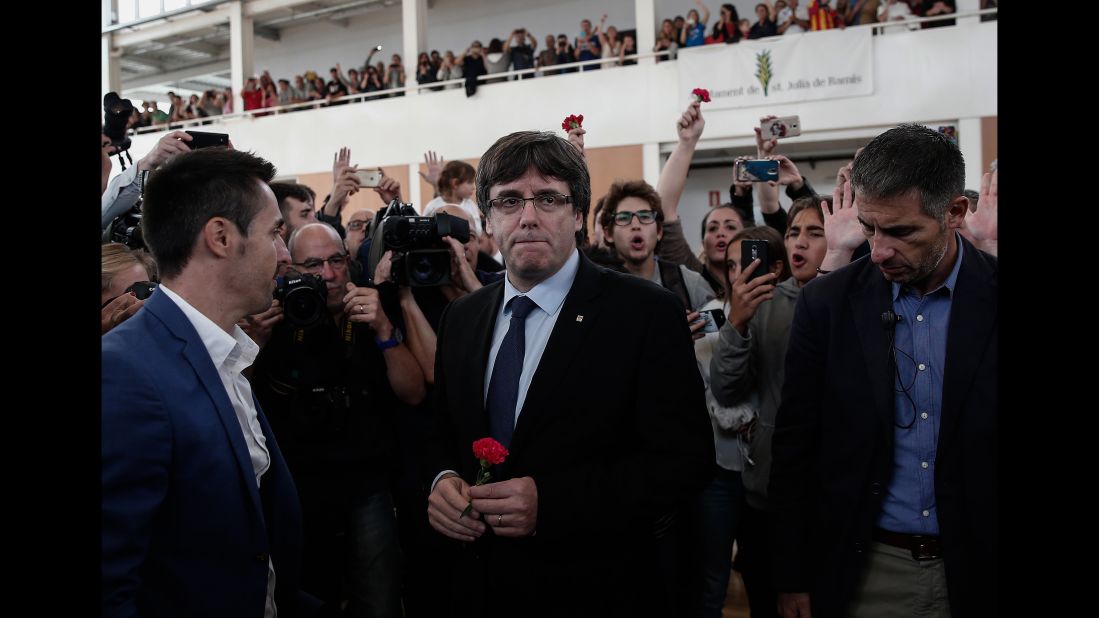 Catalan President Carles Puigdemont, center, arrives to inspect a sports hall as police interve in Girona, Spain. Puigdemont condemned "indiscriminate aggression" against peaceful voters.