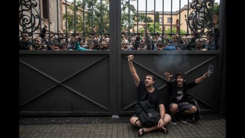 Pro-referendum supporters lock a gate to a polling station as members of the Spanish National Police arrive to control the area during voting at the Escola Industrial of Barcelona.