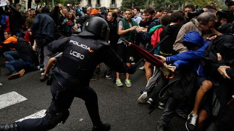 Baton-wielding Spanish National Police clash with pro-referendum supporters in Barcelona.