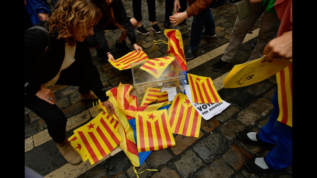 Pro-independence supporters cover a mock ballot box with Estelada Catalan flags in Pamplona, northern Spain.