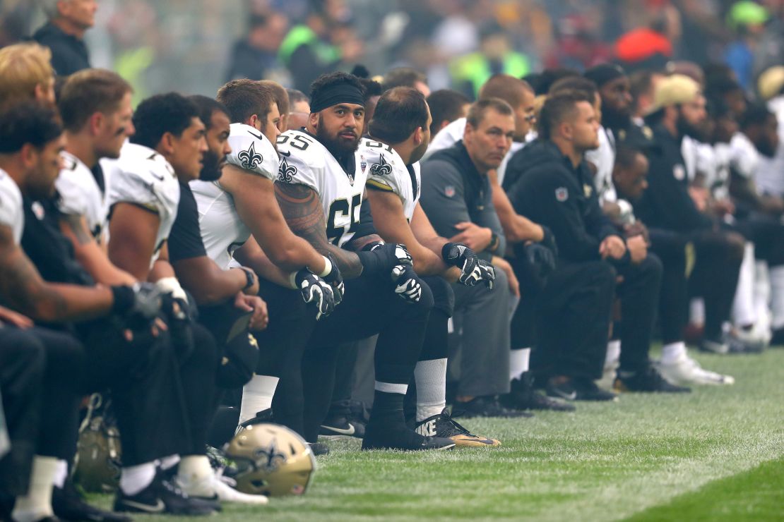 The New Orleans Saints team kneels before standing for the National Anthem in a game against the Miami Dolphins in London's Wembley Stadium. 