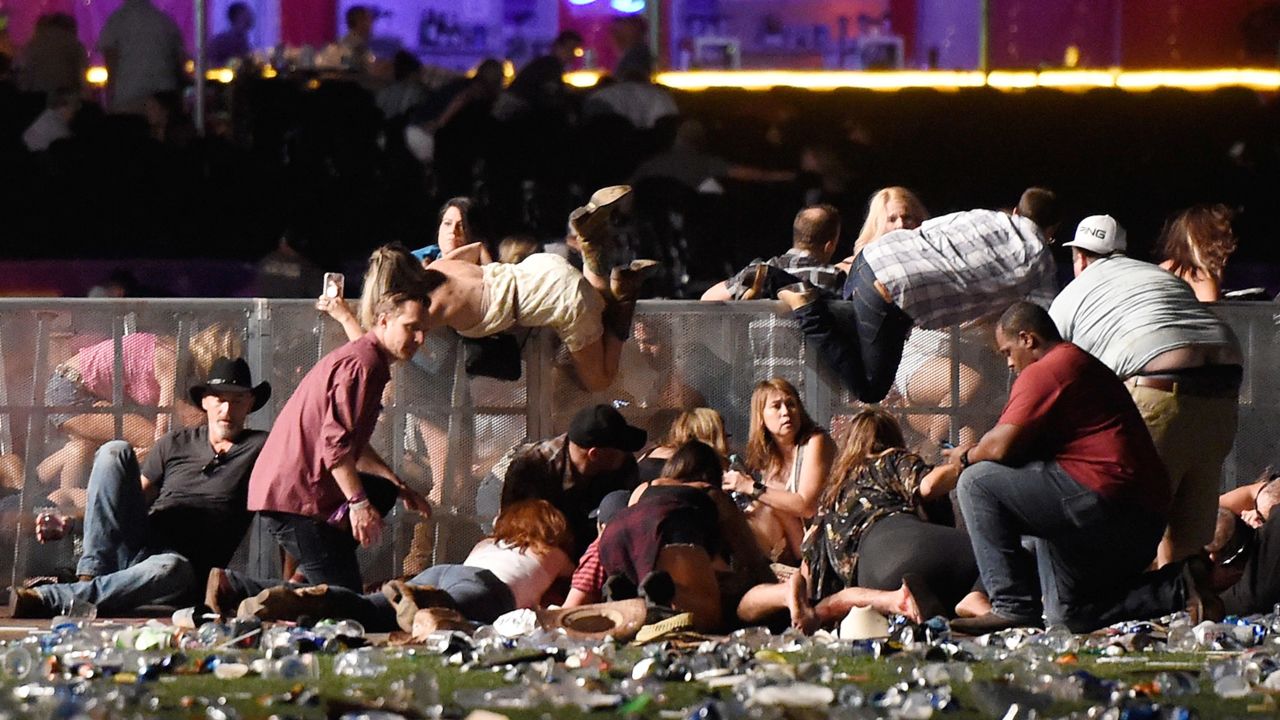 People scramble for cover at the Route 91 Harvest country music festival after gun fire was heard on  October 1, 2017 in Las Vegas, Nevada. 