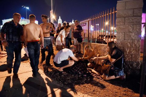 People gather around a victim outside the festival grounds.