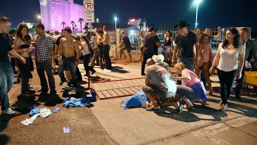 LAS VEGAS, NV - OCTOBER 01:  People tend to the wounded outside the Route 91 Harvest Country music festival grounds after an apparent shooting on October 1, 2017 in Las Vegas, Nevada. There are reports of an active shooter around the Mandalay Bay Resort and Casino.  (Photo by David Becker/Getty Images)