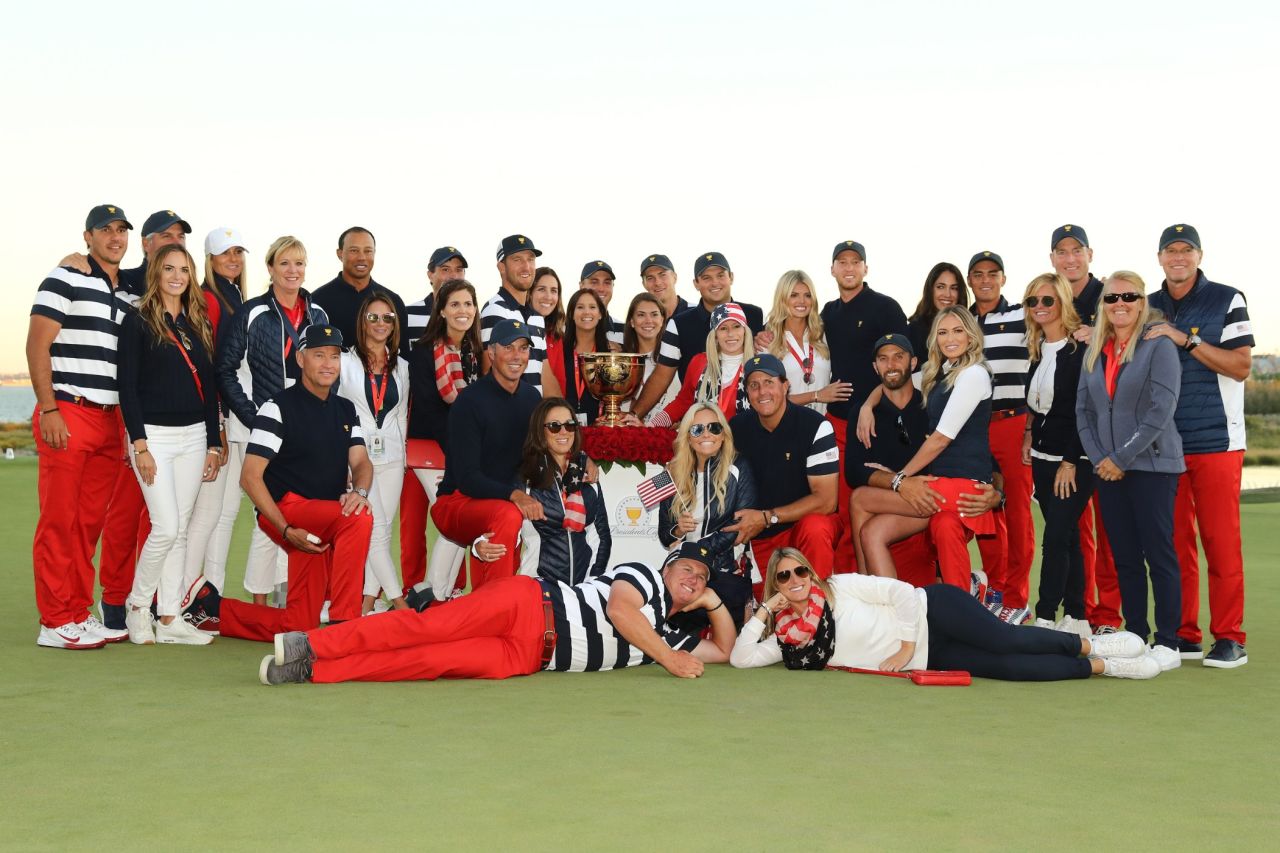 The US players and their wives and partners pose with the trophy after victory was assured.
