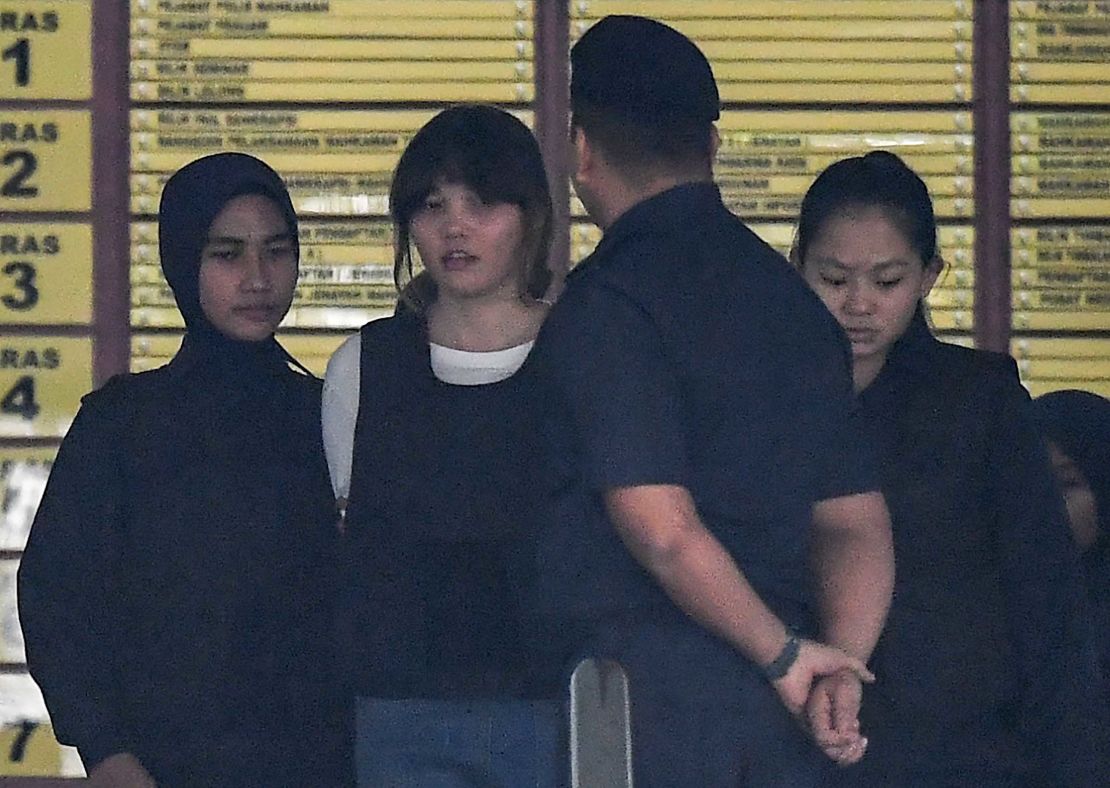 Police escort Vietnamese defendant Doan Thi Huong (2nd left) after her trial on October 2.