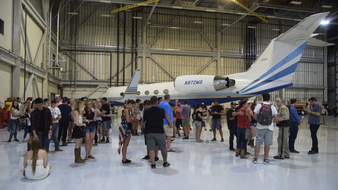 Police arrive at the Sands Corporation plane hangar where some people ran to safety after the shooting.