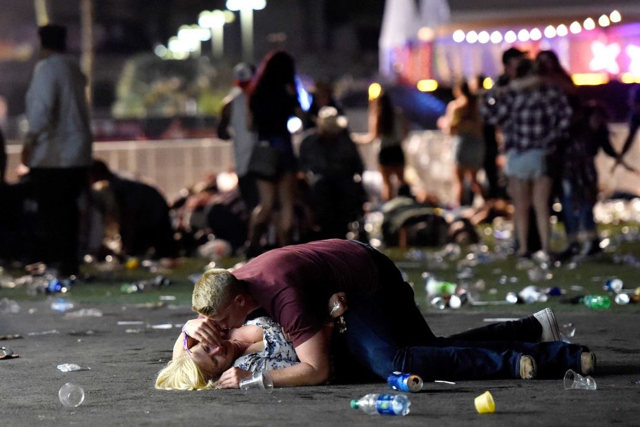 A man lays on top of a woman as others flee the festival grounds. The woman reportedly got up from the scene. 