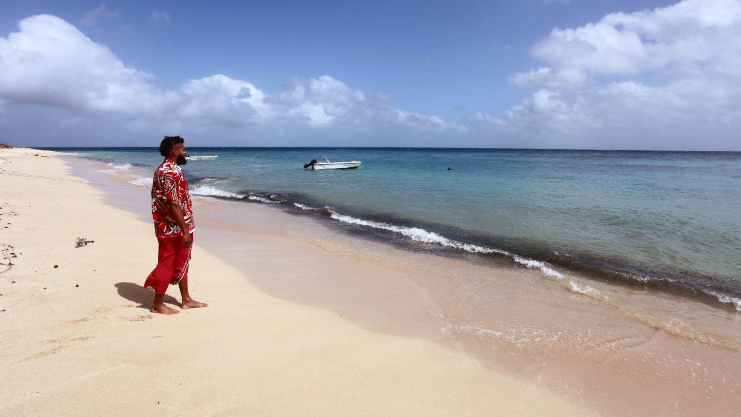 Australian NBA star Patty Mills walks on a beach on the small island of Mer. 