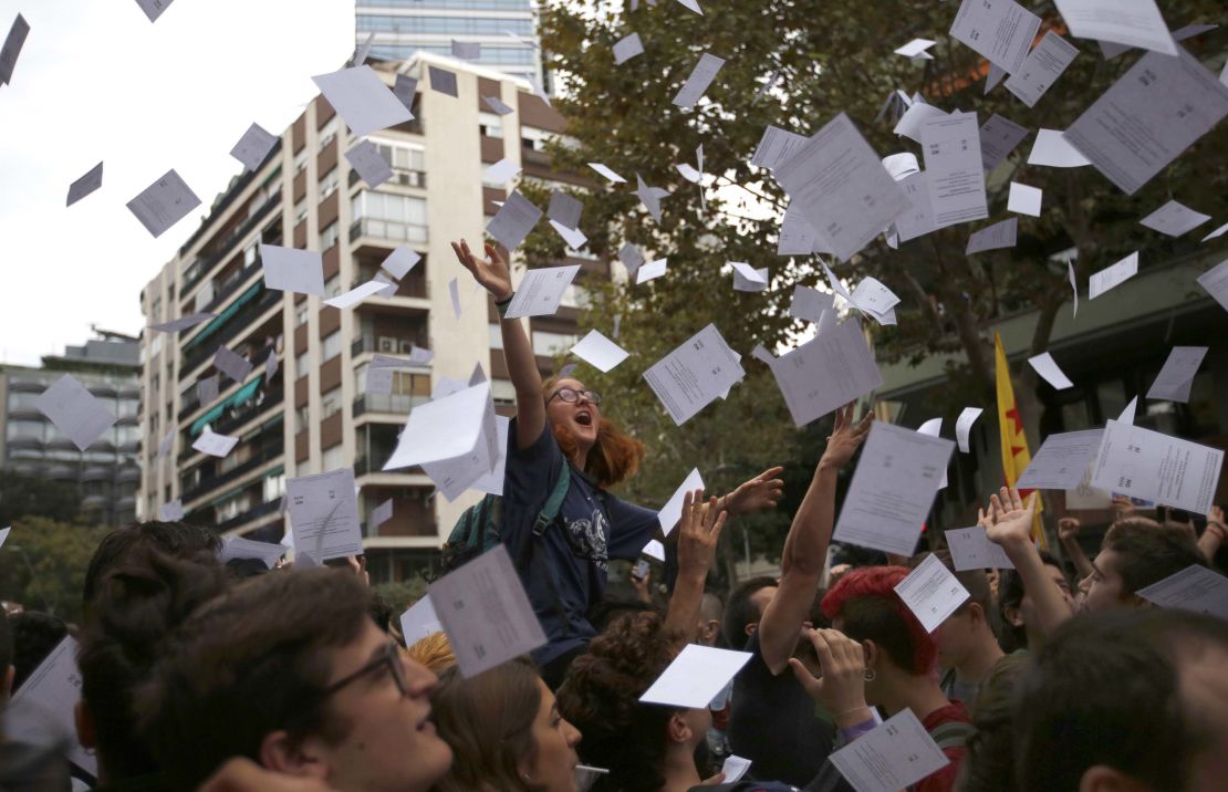 Protestors throw referendum ballots as they rally in front of Spain's ruling Partido Popular  headquarters in Barcelona.