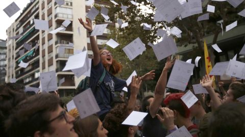 Protestors throw referendum ballots as they rally in front of Spain's ruling Partido Popular  headquarters in Barcelona.