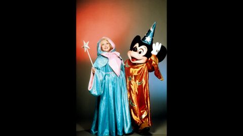 White and Mickey Mouse pose for a photo at Disneyland in 1988. 