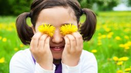 Cute child with Dandelion flowers in spring meadow. Child playing outdoors. Girl is happy outside and having fun.; Shutterstock ID 281486129; Job: -