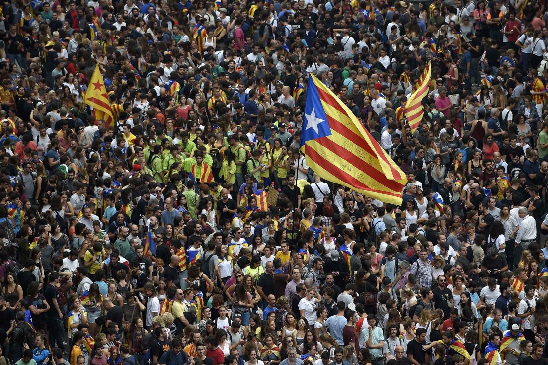 Protesters wave a Catalan pro-independence 'Estelada' flag as they gather at the Placa de la Universitat square in Barcelona during a general strike in Catalonia called by Catalan unions on October 3, 2017.
