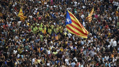 Protesters wave a Catalan pro-independence 'Estelada' flag as they gather at the Placa de la Universitat square in Barcelona during a general strike in Catalonia called by Catalan unions on October 3, 2017.