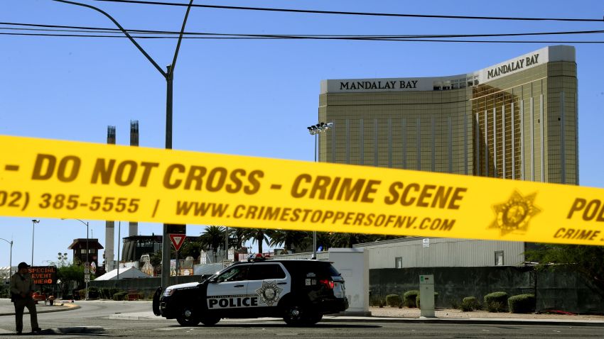TOPSHOT - Crime scene tape surrounds the Mandalay Hotel (background with shooters window damage top right) after a gunman killed at least 58 people and wounded more than 500 others when he opened fire on a country music concert in Las Vegas, Nevada on October 2, 2017. 
Police said the gunman, a 64-year-old local resident named as Stephen Paddock, had been killed after a SWAT team responded to reports of multiple gunfire from the 32nd floor of the Mandalay Bay, a hotel-casino next to the concert venue. / AFP PHOTO / Mark RALSTON        (Photo credit should read MARK RALSTON/AFP/Getty Images)
