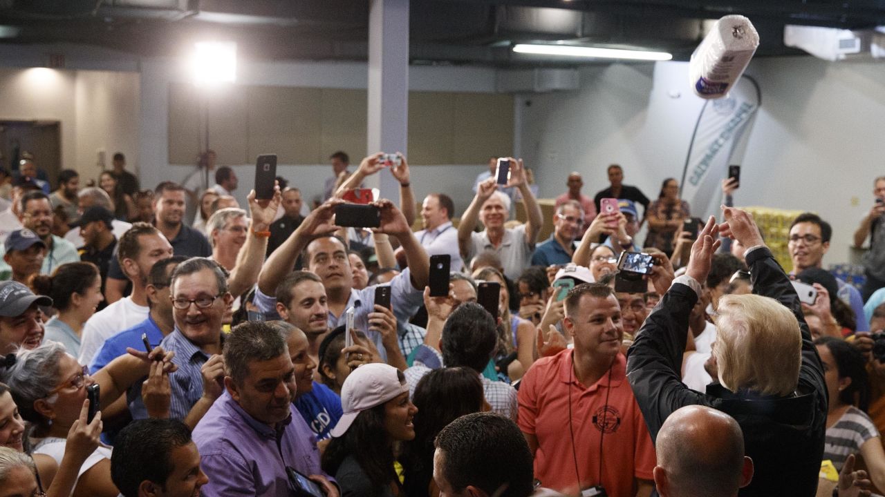 President Donald Trump tosses paper towels into a crowd as he hands out supplies at Calvary Chapel on October 3, 2017, in Guaynabo, Puerto Rico.