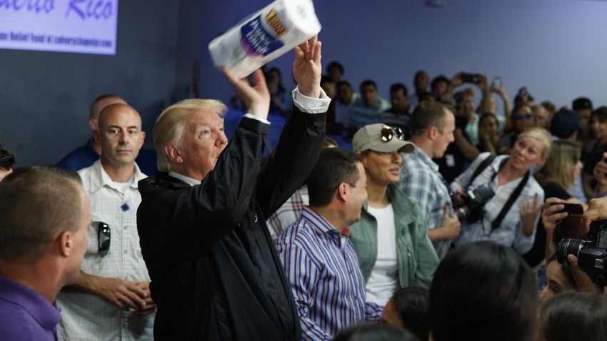 President Donald Trump tosses paper towels into a crowd as he hands out supplies at Calvary Chapel, Tuesday, Oct. 3, 2017, in Guaynabo, Puerto Rico. Trump is in Puerto Rico to survey hurricane damage. (AP Photo/Evan Vucci)