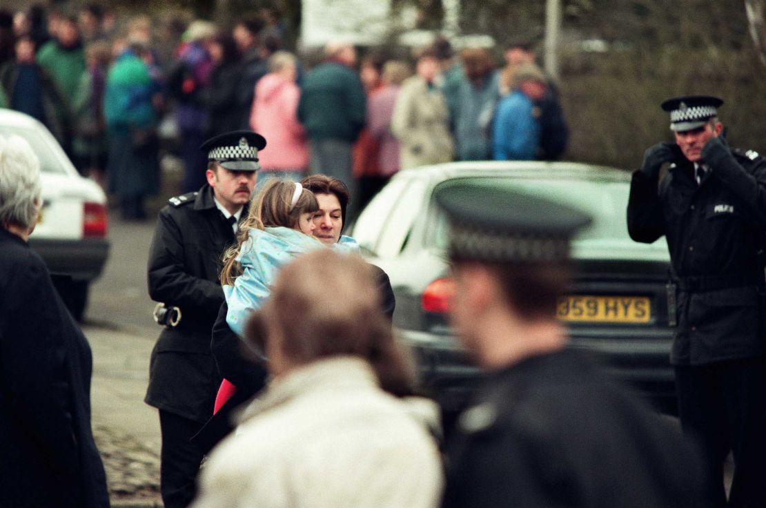 A young girl is carried away from the Dunblane primary school in Scotland shortly after the shooting in 1996.