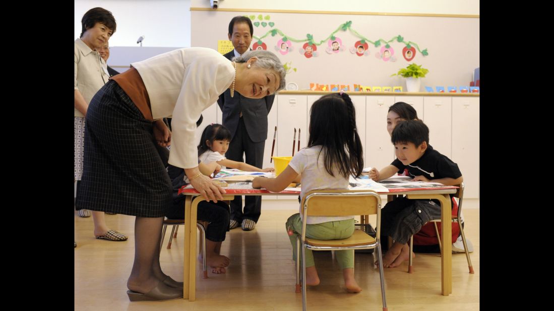 Japanese Empress Michiko, left, chats with a girl while watching children draw pictures at a daycare center in Tokyo on May 15, 2009.  
