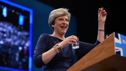 Britain's Prime Minister Theresa May holds up a throat sweet given to her by Britain's Chancellor of the Exchequer Philip Hammond as she delivers her speech on the final day of the Conservative Party annual conference at the Manchester Central Convention Centre in Manchester, northwest England, on October 4, 2017. / AFP PHOTO / Oli SCARFF        (Photo credit should read OLI SCARFF/AFP/Getty Images)