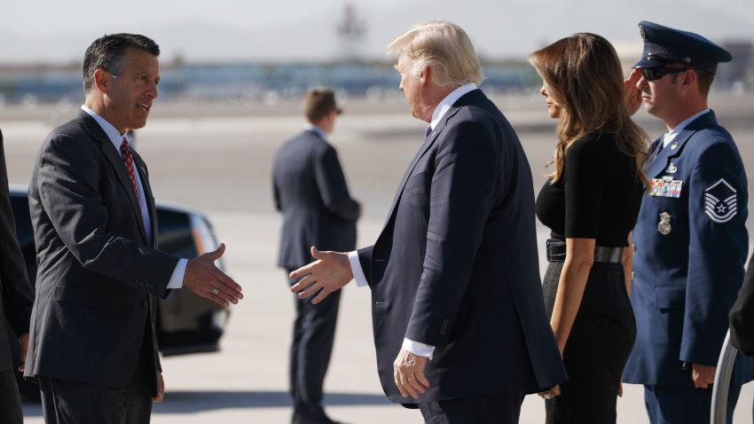 Nevada Gov. Brian Sandoval, left, greets President Donald Trump and first lady Melania Trump as they arrive Wednesday, Oct. 4, 2017, at Las Vegas McCarran International Airport to meet with victims and first responders of the mass shooting. (AP Photo/Evan Vucci)