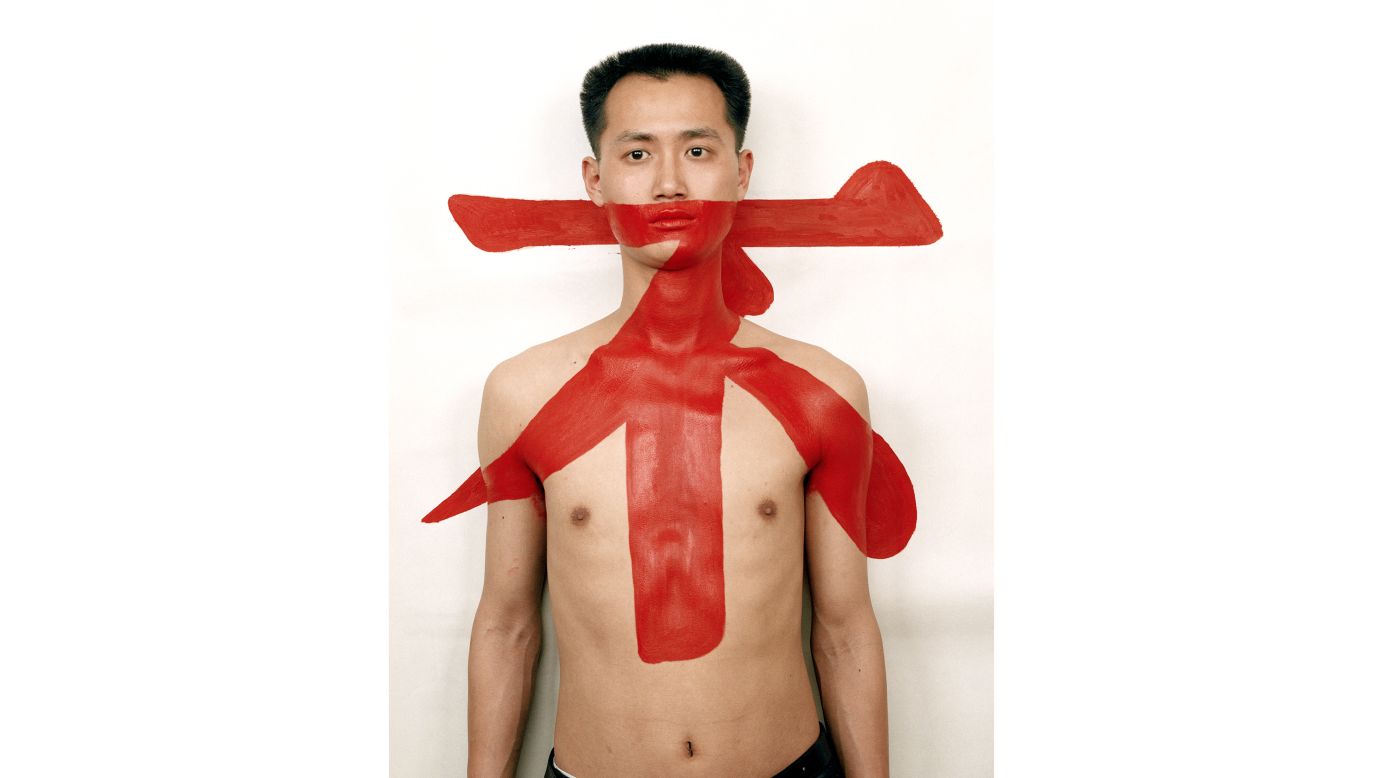The 1990s was a period of experimentation. Many of the works dealt with explorations of the self and identity. Qiu Zhijie painted the Chinese character "No" across his body and the wall behind him such that his body becomes negated in the process. "Self portraiture was rejected during the Cultural Revolution — collectivity was great, individuality was bad. Artists afterward tried to rediscover their individuality," says Wu Hung. <em>Qiu Zhijie "Tattoo 1" (1997).</em>