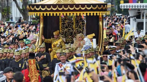 The Sultan and Queen Saleha wave from the royal chariot during the procession.