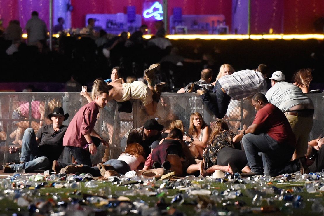 People scramble after gunfire strikes the Route 91 Harvest country music festival in Las Vegas.