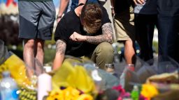 LAS VEGAS, NV - OCTOBER 04:  Bry Thompson, 21, of Las Vegas kneels at a makeshift memorial set up across from the Las Vegas Village on October 4, 2017 in Las Vegas, Nevada. Thompson had friends attending the Route 91 Harvest country music festival when a lone gunman opened fire on the crowd killing at least 59 people and injuring more than 500. The massacre is one of the deadliest mass shooting events in U.S. history. Thompson's friends were unhurt.  (Photo by David Becker/Getty Images)