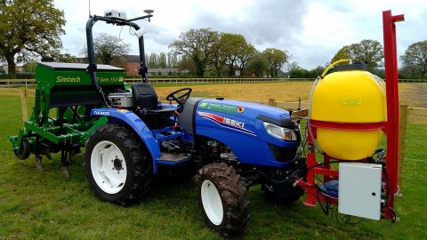 An automated tractor worked in the barley field.