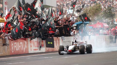 Mika Hakkinen is saluted by his McLaren team after winning the world title at Suzuka in 1998