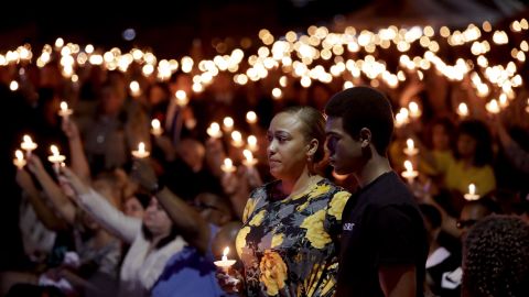 Veronica Hartfield, stands with her son, Ayzayah during a candlelight vigil for her husband, Charleston.