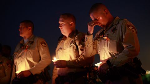 Colleagues of officer Charleston Hartfield hold candles during the vigil.