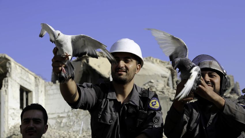 DAMASCUS, SYRIA - AUGUST 22 : Men, members of Syrian civil defense organization, White Helmets let a white pigeon to fly for people who lost his life in chemical attack that in the Eastern Ghouta region of Damascus, Syria on August 22, 2017. It is the 4th anniversary of chemical weapons attack near countrysides of Zamalka that Assad Regime's forces carried out. (Photo by Amer Almohibany/Anadolu Agency/Getty Images)