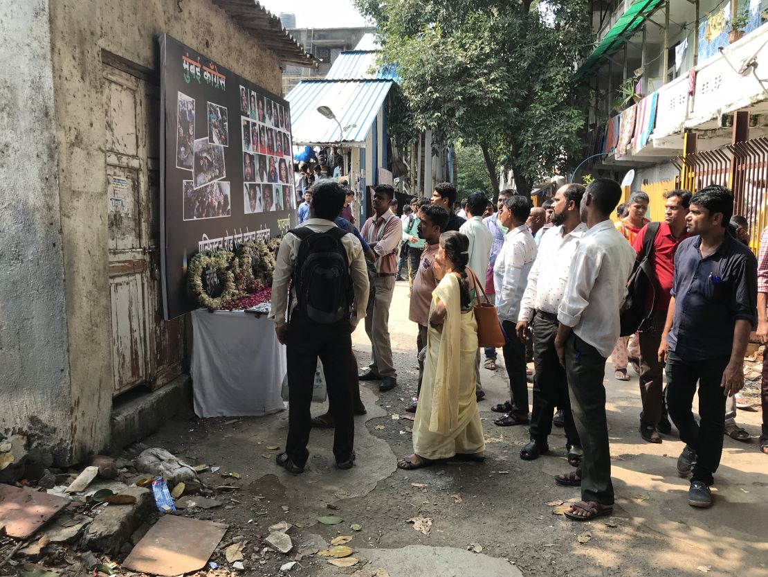 Commuters pause to look at photos of the stampede victims at Prabhadevi station, formerly known as Elphinstone station.