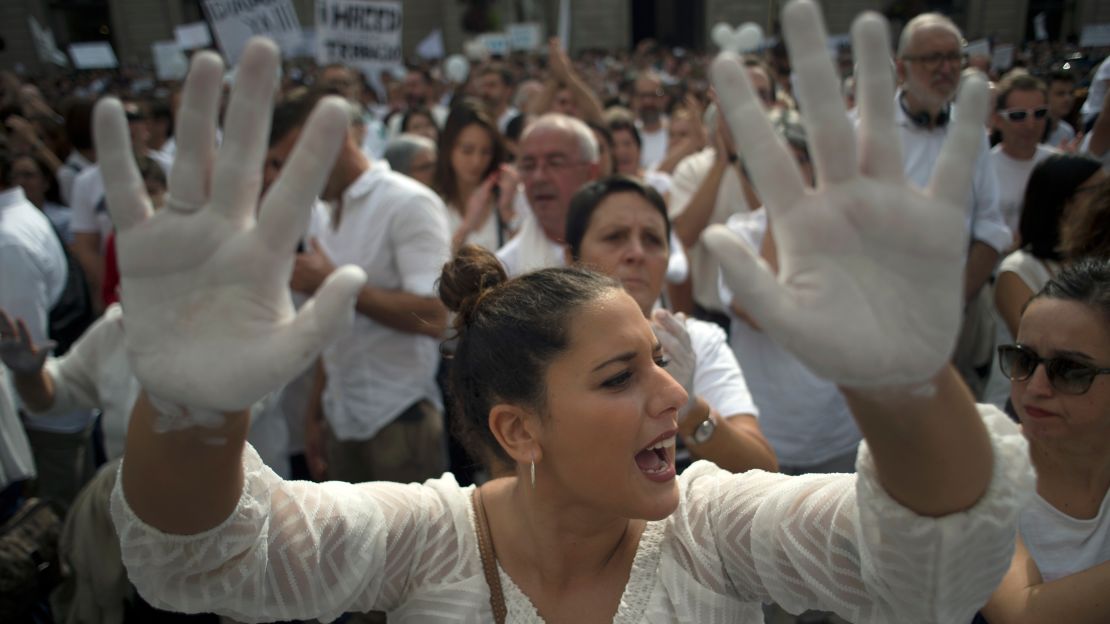 A woman shows her hands painted in white at a rally Saturday in Barcelona calling for dialogue.