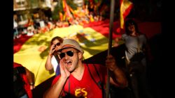 Demonstrators hold Spanish flags and shout slogans as they gather near a headquarters of federal police in Barcelona, Spain, Sunday Oct. 8, 2017. Demonstrators gathered early in Barcelona on Sunday ahead of a march to show support for the Spanish union and call on Catalonia not to declare independence. (AP Photo/Francisco Seco)