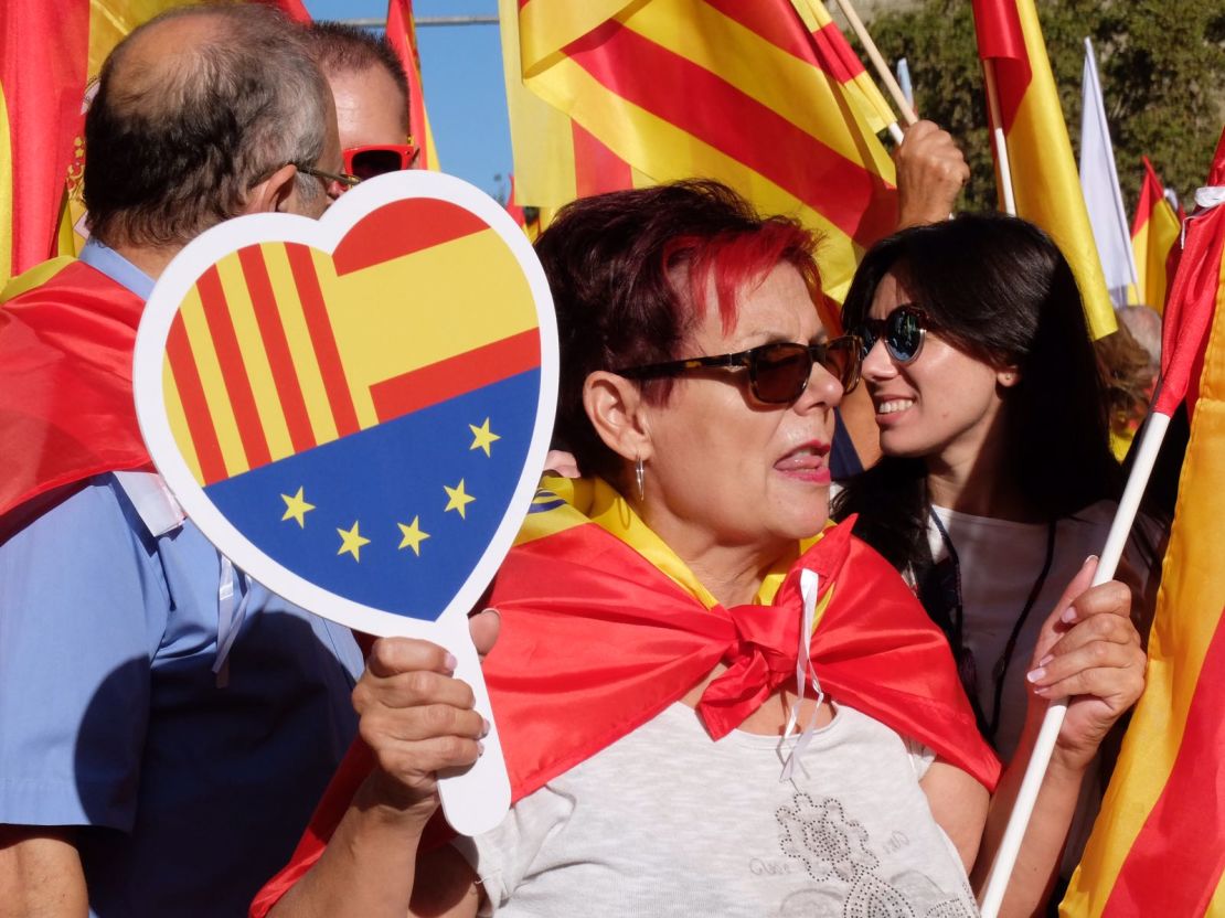 A woman takes part in a pro-unity march in Barcelona on Sunday with a heart bearing the flags of Catalonia, Spain and the European Union.